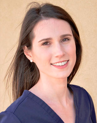 Woman in a blue shirt, smiling, posing for a portrait.