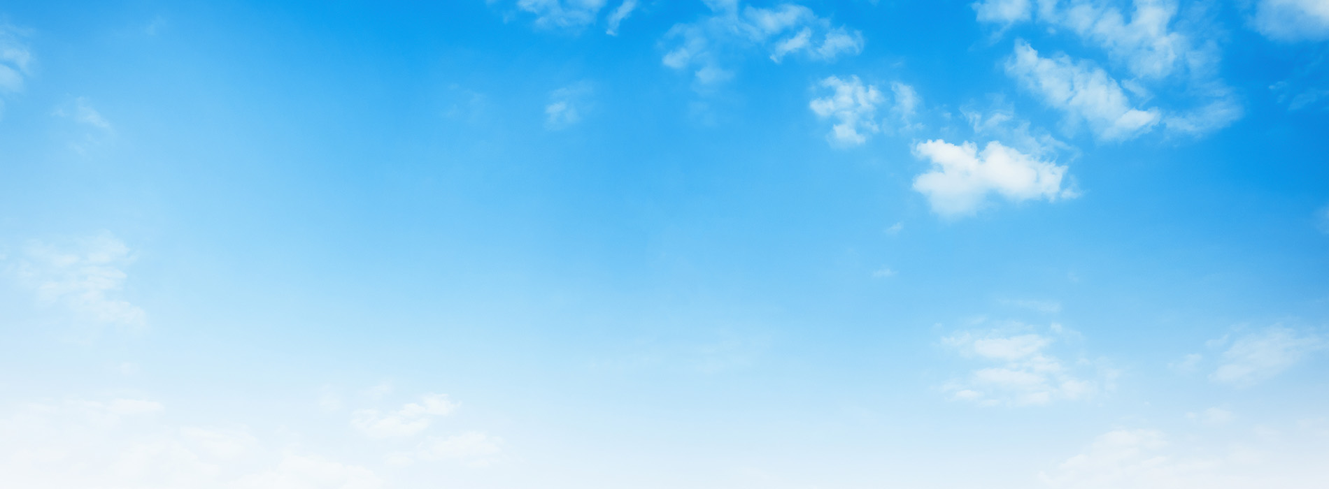 The image shows a clear blue sky with a few clouds, and there is a horizon line where the sky meets the land.