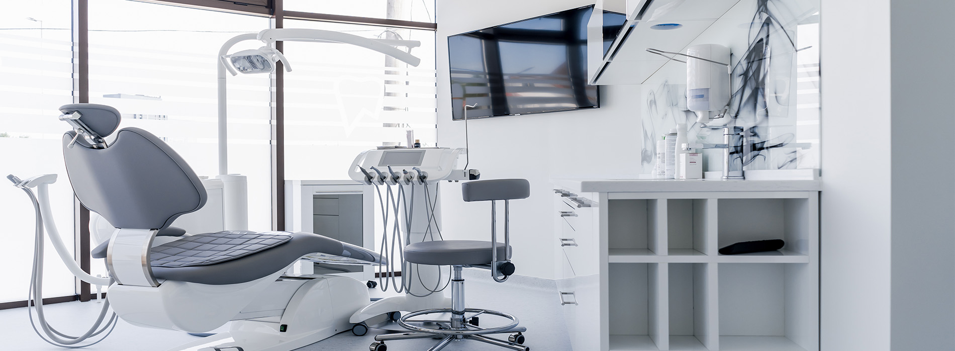 The image shows a modern dental office interior with various pieces of equipment and furniture, including chairs, dental tools, and a reception area.