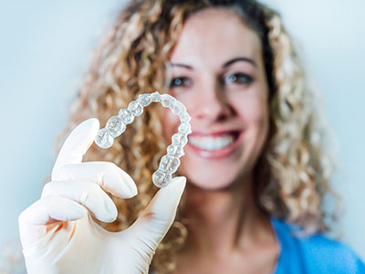 A woman holding a transparent dental implant.