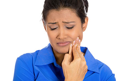 A woman with a concerned expression is looking down at her hand, which she appears to be examining or cleaning.