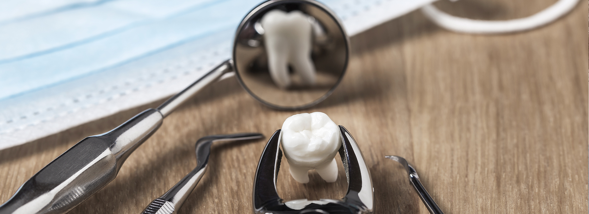 An upside-down spoon with a reflection of a white object, possibly a marble or ball, on a wooden surface.