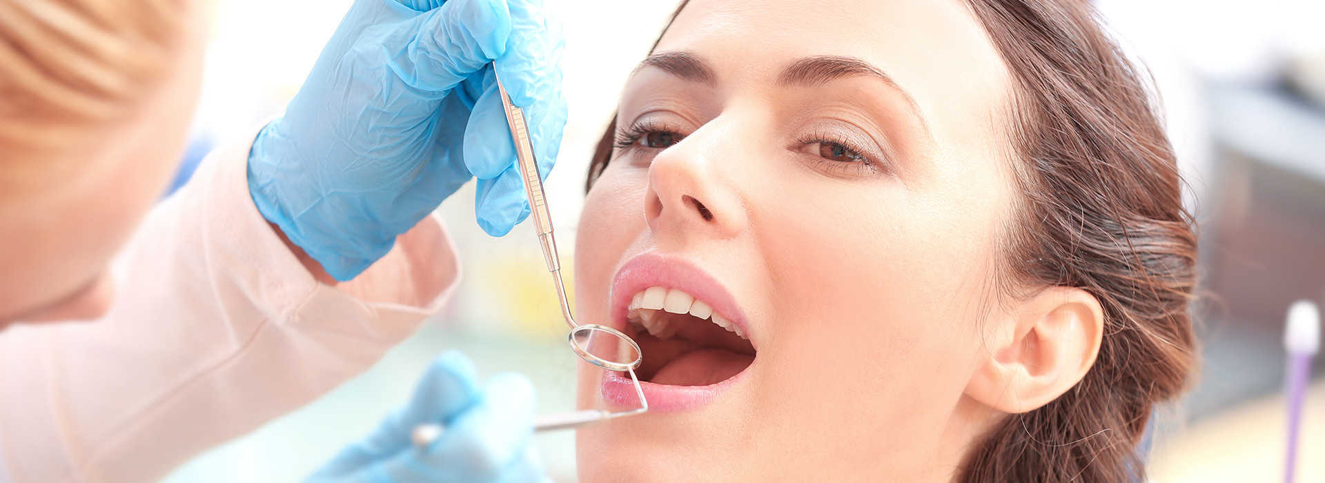 Woman receiving dental implant procedure with dental practitioner.