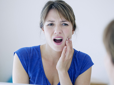 Woman with hand on her face, expressing concern or worry.